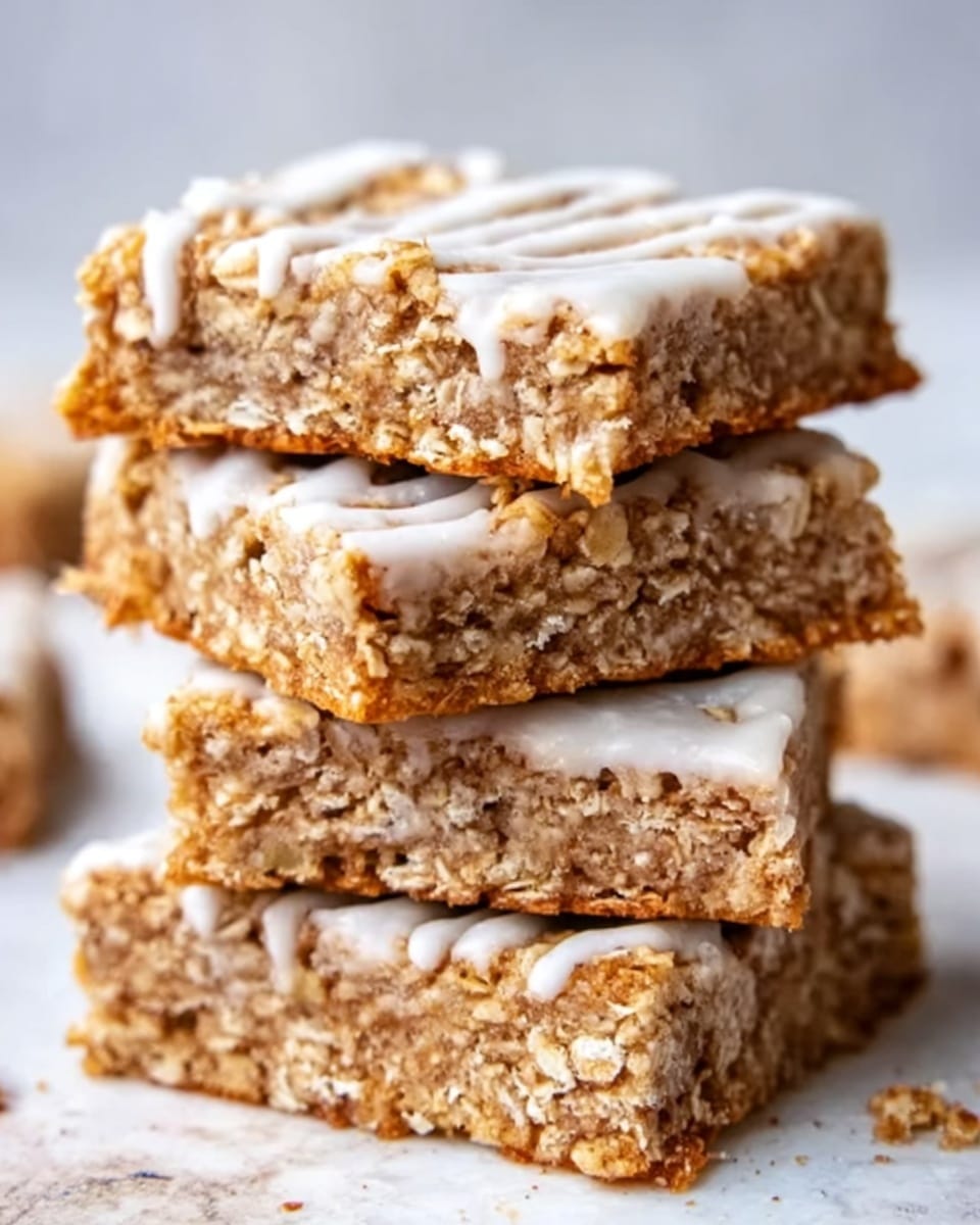The image shows a stack of four oat bars on a white marbled surface. Each bar has three layers: a bottom layer made of a golden-brown oat mixture with a rough texture, a middle layer which is similar in color but slightly softer looking, and a top layer covered with a smooth, white icing drizzle. The oatmeal texture is visible with pieces of oats sticking out. The stack is slightly uneven, showing the thickness of each bar clearly. photo taken with an iphone --ar 4:5 --v 7